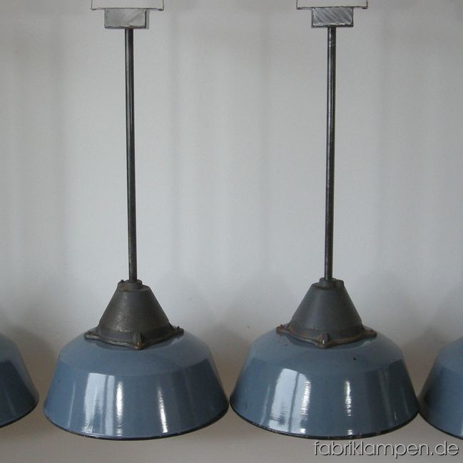 4 pieces grey enamel industrial lamps in original condition, with traces of use and age. Material: enameled sheet and casted iron. The lamps are new electrified (tested) and equipped with new iron pipe and baldachin. Total height ca. 84 cm (33 inches – lamp ca. 28 cm (11 inches), pipe ca. 56 cm (22 inches), diameter of the lamp ca. 41 cm (16,1 inches).