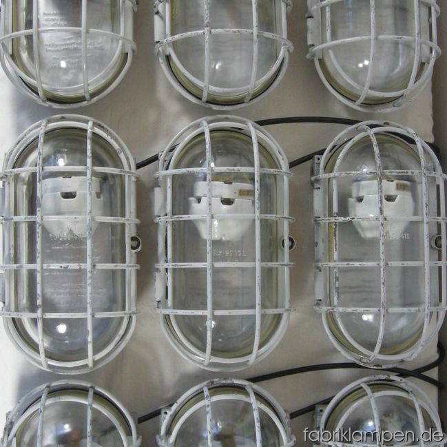Industrial (mine) lamps (explosionsproof) with grids. The lamps have traces of use and age (some rost, chips and scratches). Material: aluminium and steel (safety grids). The lamps are cleaned and newly electrified – they can be used with E27 bulbs. Total height: ca. 36 cm (14,2 inches, plus iron parts for the mounting on wall or ceiling), width ca 20 cm (7,9 inches), height ca. 18 cm (10,2 inches). 11 pieces available.