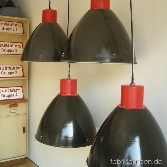 Impressive industrial lamps in black and red. Material: black enameled sheet and red painted top, with wire rope suspension. The lamps are cleaned and newly electrified, with E27 sockets. Total height: ca. 49 cm (19,3 inches). Diameter of the shade ca. 53 cm (21 inches).