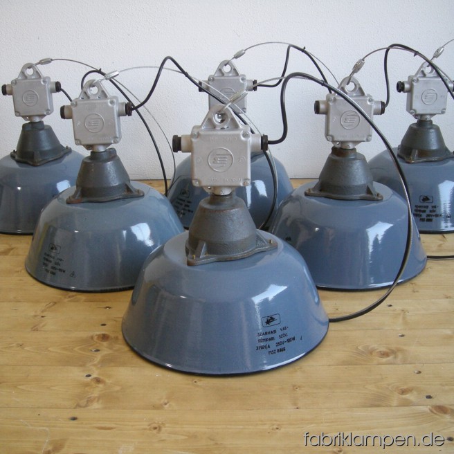 Gray industrial lamps with enameled shades and aluminium distribution boxes. Material: casted iron, aluminium and gray enameled sheet. Newly electrified, with wire-rope suspension. Height of the lamps ca. 36 cm (14,2 inches), diameter of the shades ca. 36 cm (14,2 inches).