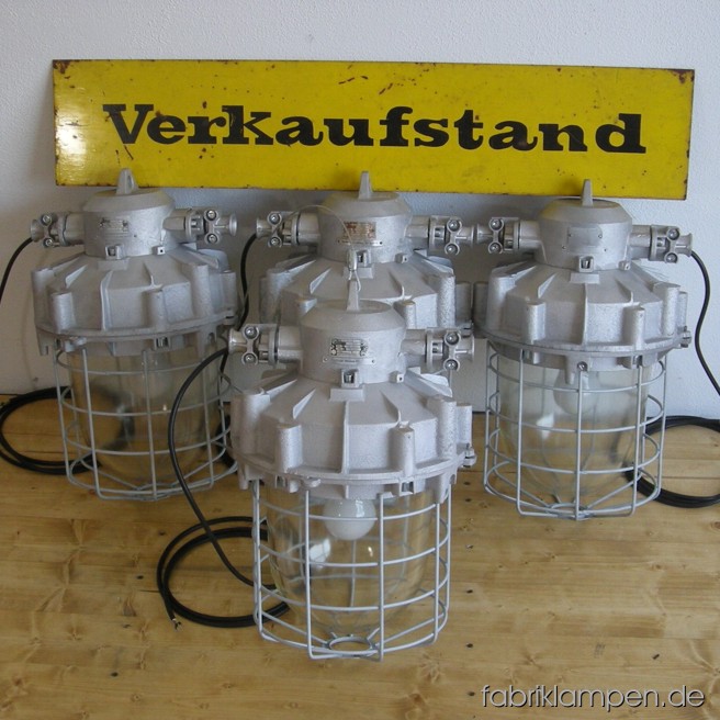 Huge industrial bunker lamps. Material: aluminium, steel, glass. The lamps are renewed: cleaned, the safety grids are sandblasted and new galvanized; they are newly electrified, with ca. 2 m wire. Total height: ca. 55 cm (21,7 inches), weight ca. 14 kgs. The small bunker lamp on the last gallery picture is our benchmark: it is 38 cm (15 inches) height.
