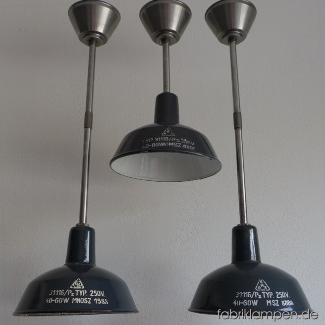 Nice small industrial lamps with inscription. Material: blue (some grayish) enameled sheet. Newly electrified, with steel-tube suspension and canopy. Height of the shade is ca. 18 cm (7 inches), diameter of the shade is ca. 26 cm (10,2 inches), total height of the Lamps between 45 and 74 cm (17,7 – 29,1 inches).