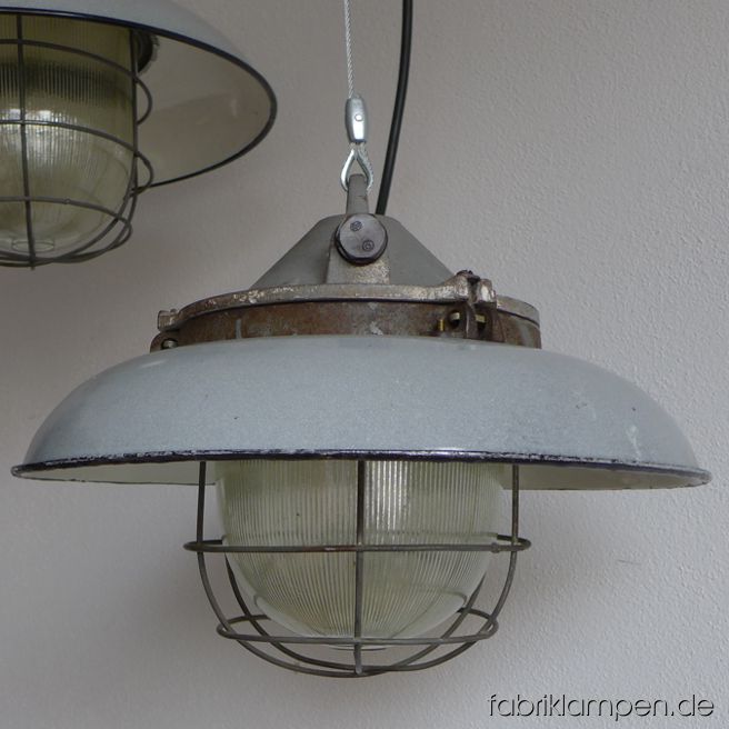 Rare gray bunker lamps with enameled shades. Material: gray enameled sheet, casted iron head. Newly electrified, with E27 sockets. We have 3 pieces on stock. Height of the lamps ca. 29 cm (11,4 inches), diameter of the shades ca. 41 cm (16,1 inches).