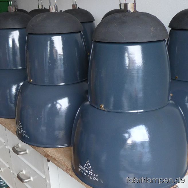 Robust grayish blue enamel lamps from an old textile factory. The lamps have light traces of usage and age. Material: grayish blue enameled steel sheet, casted iron cap. Newly electrified, with E27 sockets. We have 35 pieces on stock. Height of the lamps ca. 50 cm (19,7 inches), diameter of the shades ca. 40 cm (15,7 inches). Also in other variants on stock (black, bigger, with safety glass) – details & prices of these versions on request.