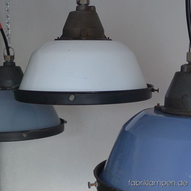 Old enamel factory lamps with safety grid and glass. We have these lamps in gray, blue and white and in mixed colours (bluish gray or grayish blue). The lamps have the slight traces of usage and age. Material: casted iron top, gray, blue or white (inside white) enameled steel sheet. Cleaned, newly electrified, with E27 ceramic sockets. We have 80 pieces in stock. Height of the lamps ca. 23 cm (9 inches), diameter of the shades ca. 36 cm (14,2 inches), diameter with safety grid 37 cm (14,6 inches).
