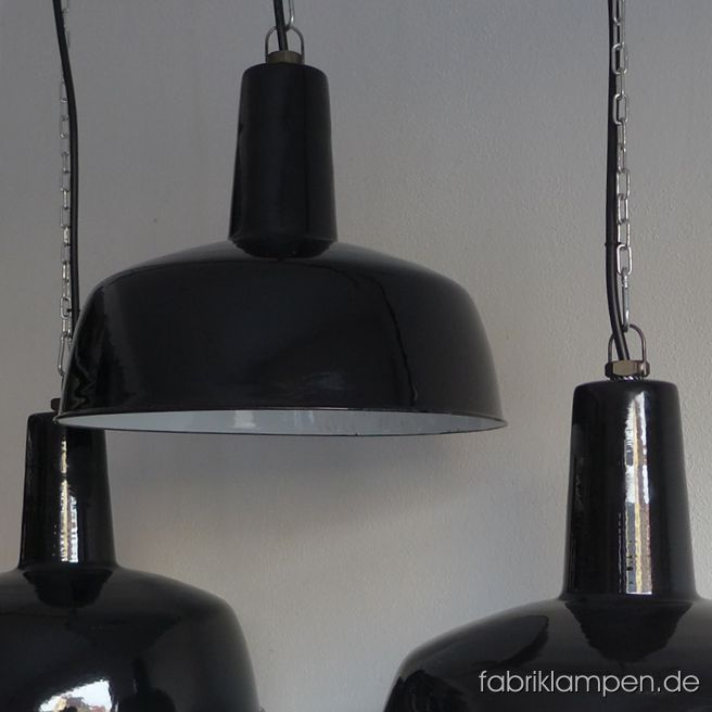 Rare antique black enamel lamps in classy form. These well preserved old factory lamps have the light traces of usage and age. Material: black (inside white) enameled steel sheet. Cleaned and newly electrified, with E27 ceramic bulbholders. Height of the lamps ca. 33 cm (13  inches), diameter of the shades ca. 41 cm (16,1 inches). 