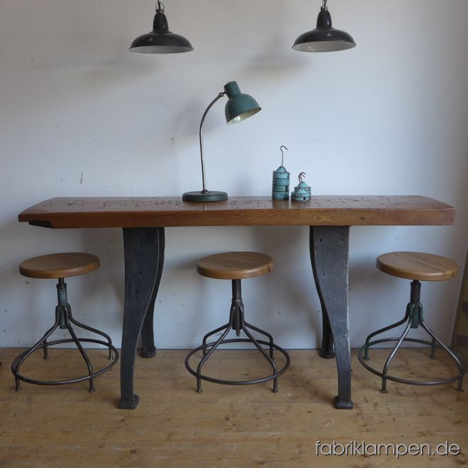 Old industrial table (workbench), restored. The casted iron pedestals are cleaned and waxed. Very fat and heavy tabletop (ash massiv, made of one piece of wood) with nice traces of use on the surface. Perfectly cleaned and waxed. Height: …. cm, Tabletop: 174 cm x 41,5 cm x 7 cm (lenght x depth x thicknesss), Width of the pedestal at the bottom: 59 cm.  