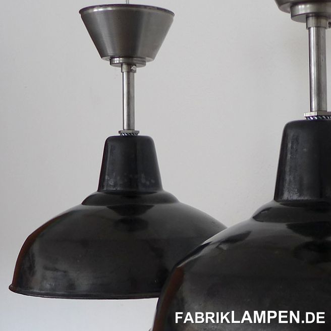 Old industrial lamps from the 1930’s. The enamel lamps have strong traces of usage and age. Material: black (inside white) enameled steel sheet. Cleaned and conserved, newly electrified, with E27 ceramic sockets. Suspension: steel-tube suspension and canopy (waxed). Height of the shade is ca. 21 cm (8,3 inches), diameter of the shade is ca. 35 cm (13,8 inches), total height of the lamps is 38 cm (15 inches). 