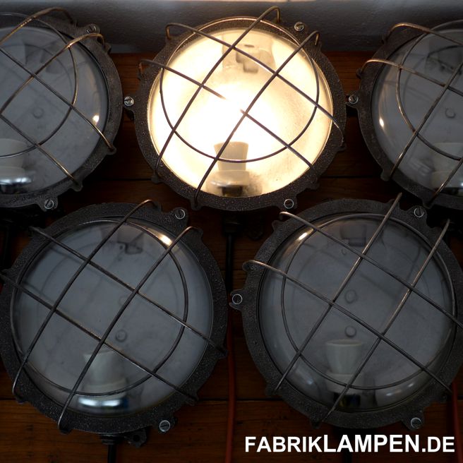 Alte Wandlampe, Schiffslampe, restauriert. Schöne alte gusseiserne Fabriklampen, geeignet sowohl als Wandlampe als auch als Deckenleuchte. Material: runde Gehäuse aus Gusseisen, mit Stahlgitter und Schutzglas. Die Lampen sind restauriert: gereinigt, aufgearbeitet und konserviert. Diese alten Industrielampen sind neu elektrifiziert (E27 Porzellanfassung, ausgestattet mit ca. 2 m Kabel). Unsere Empfehlung für diese Lampen sind die LED-Birnen. Die Lampen sind an der Wand mit „Birne nach oben“ zu montieren. Die Abmessungen: Durchmesser ca. 27/30 cm (Gehäuse/mit Schrauben & Füßen), Höhe ca. 14 cm. Das Gewicht beträgt 5,2 Kg. 