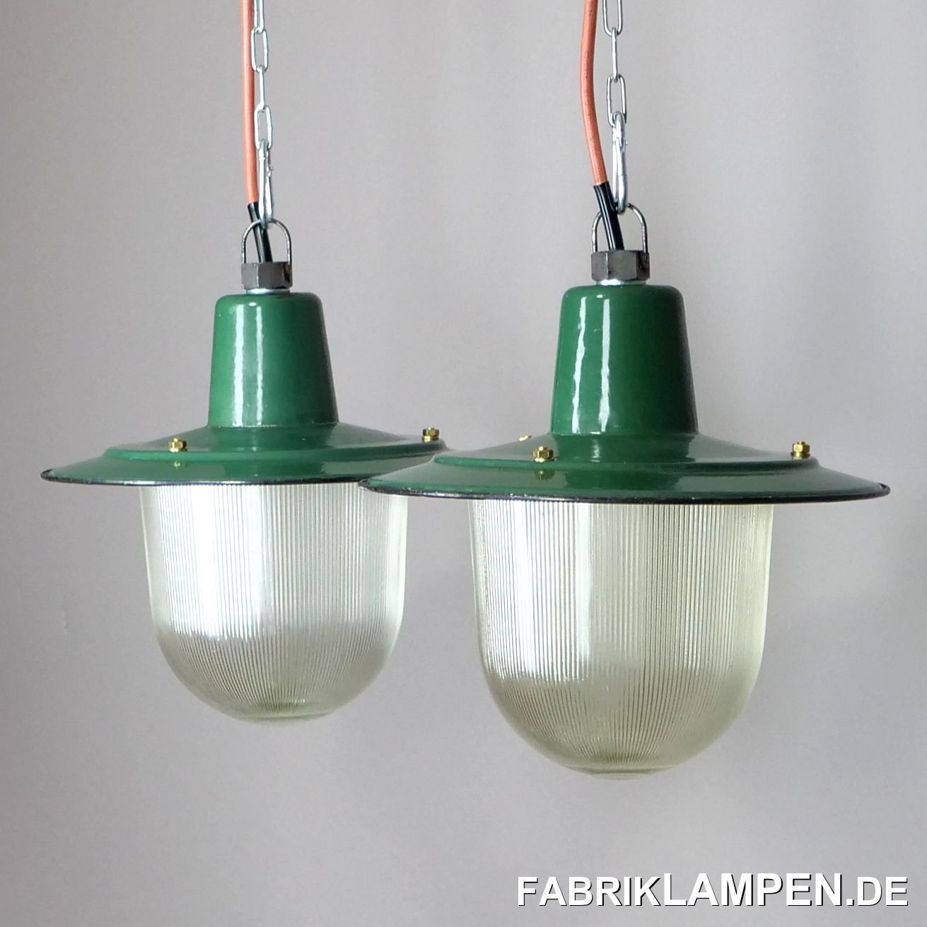  Old enamel factory lamps from the 1950s, a pair. Very rare variant with company logo on the enamel shade and protective glass. The heavy safety glass is ribbed.These beautiful factory lamps have some traces of the past decades, such as chipping, rust spots, scratches, discoloration and so on, making each lamp unique.The industrial lamps are restored: cleaned, preserved and re-electrified, with new E27 ceramic sockets.Material: green (inside white) enameled steel sheet, with protective glass.The lamps can also be used without glass, as open lamps.Dimensions: Height of the lamps about 28 cm (without suspension eye), diameter about 31.5 cm. Height of the shade only 12 cm.The old factory lamps are supplied with 2 meters of cable. For an extra charge, the lamps can also be supplied with chain or steel tube suspension. We can also offer canopies.2 pieces in stock, for sale only as a pair. 